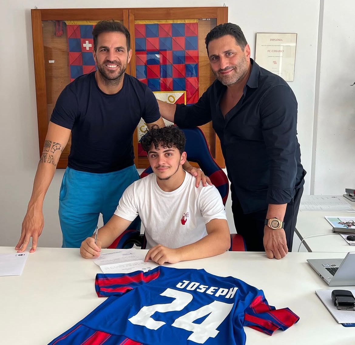 A young player signing with Cesc Fabregas present